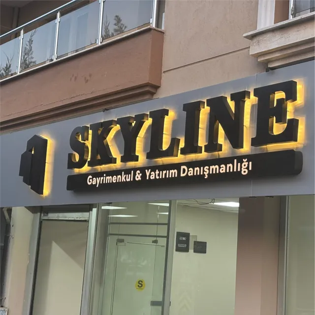 Gri cephe paneli üzerinde arkadan aydınlatmalı alüminyum kutu harf tabela